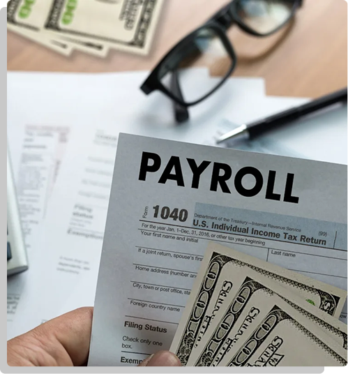 Hand holding a wooden block that reads payroll
